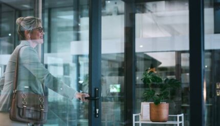 middle aged businesswoman smiling while exiting the building