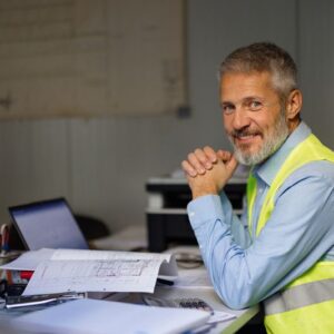 construction owner in green vest smiling